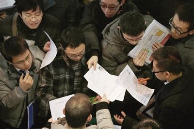 今年1月6日,在国展一招聘单位展位前,应聘者在投简历